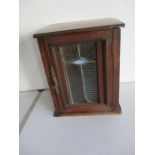 A small mahogany cupboard with stained glass panel