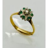 An 18ct gold diamond and emerald flower shaped ring with 9ct adjuster - Size R