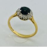 An 18ct gold ring with central sapphire with diamond surround, size P