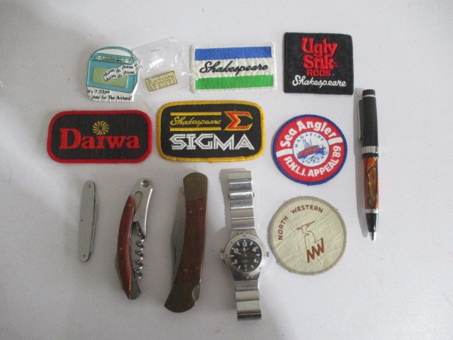 A collection of knives, patches, watch etc