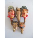 A collection of five novelty wooden bottle stoppers in the form of Norman Wisdom, Greta Garbo, Clark