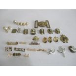 A collection of military badges, belt buckle, buttons etc.