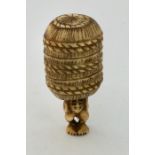 A 19th century ivory netsuke of a man carrying an oversized rice bale