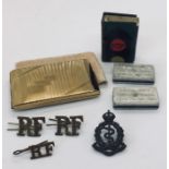 A collection of military badges, Art Deco style compact, matchbox holder etc