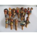 A collection of vintage wooden mechanical novelty bottle stoppers including Anri.
