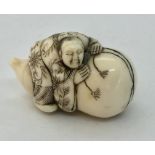 A 19th century carved ivory netsuke of a man sitting atop a gourd.