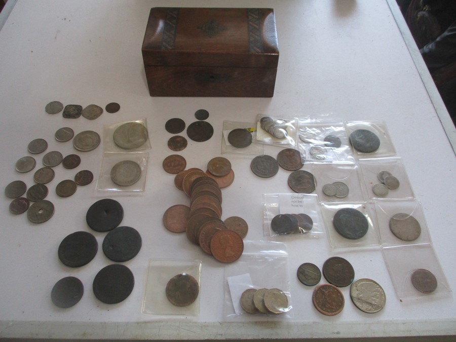 A collection of various coins in a Victorian money box