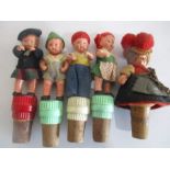 Five celluloid "doll" bottle stoppers