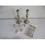 A small collection of silver plated items including pair of candlesticks, forks and serviette