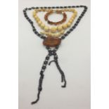 An amber bracelet, a necklace with uncut baltic amber centrepiece and a turn of the century ivory