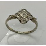 An Art Deco white gold ( hallmark rubbed) diamond cluster ring, size N 1/2