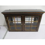 An ebonised table top display cabinet