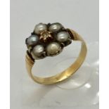A Victorian unmarked gold ( probably 18ct) ring set with a circle of seed pearls with central