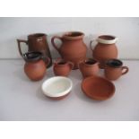 A collection of terracotta jugs and dishes, including Royal Barum Ware.