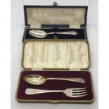 Two cased hallmarked silver Christening sets, one consisting of fork and spoon, the other a spoon