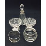 A pair of cut glass and hallmarked silver salts, one other with silver rim, a silver serviette