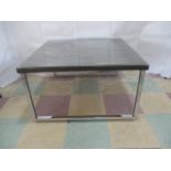 A contemporary coffee table with wood effect top and chrome legs.