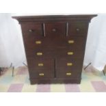 A large campaign style chest of 8 drawers with central cupboard