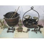 A collection of brass and cast iron items including a skillet, weights, cauldron etc.