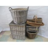 A collection of wicker items including a laundry basket, planter, log bin, picnic hamper and other