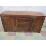 A hardwood sideboard with two cupboards and three central drawers