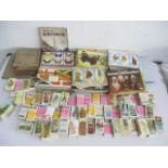 A collection of various tea and other picture cards, along with some empty cigarette picture card