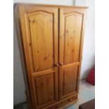 A pine wardrobe with drawer under