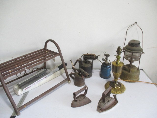 A collection of vintage blow torches, Tilley lamp, clay pigeon flinger, brass table lamp etc