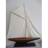 A model yacht on stand, modelled on an I class Americas Cup yacht, 152cm height, 148 cm length