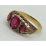 An 18ct gold ruby three stone ring with diamond infills