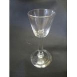 A Georgian drinking glass with rounded funnel bowl on plain stem and folded foot
