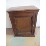 A small stained pine single door cupboard