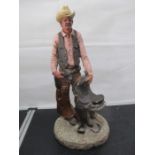 A "Monfort Original Western Sculpture" of a cowboy- slight chips to saddle
