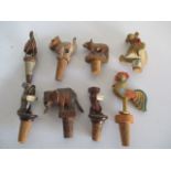 A collection of vintage wooden bottle stoppers in the form of animals, including some mechanical.