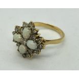 An 18ct gold ring set with four opals with a surround of diamonds in a snowflake design.