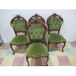 A set of four reproduction button backed dining chairs