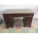 A Kneehole writing desk with green leather inset.