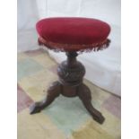 A Victorian piano stool with upholstered circular seat