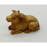 A signed netsuke of a recumbent bull