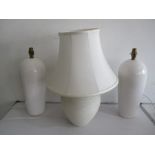 A pair of pottery lamps and one other