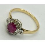 An 18ct gold and platinum ruby and diamond cluster ring with baguettes to shoulders. Size M1/2
