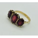 A 9ct gold dress ring set with 3 garnets. Size N1/2