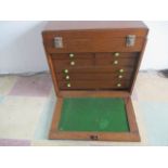 A vintage oak tool box with seven drawers and drop down front, along with some tools etc