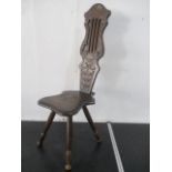A dark oak spinning chair with carved decoration