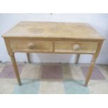 An antique pine table with two drawers