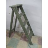 A vintage green painted wooden step ladder