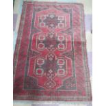 A handwoven red ground rug