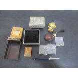 A small collection of interesting items including a Colibri lighter, playing cards, pipe, pin
