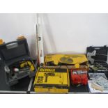 A collection of various tools and accessories including a DeWalt drill, DeWalt sander, battery
