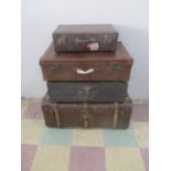 A collection of three vintage suitcases, along with a T.Howie trunk